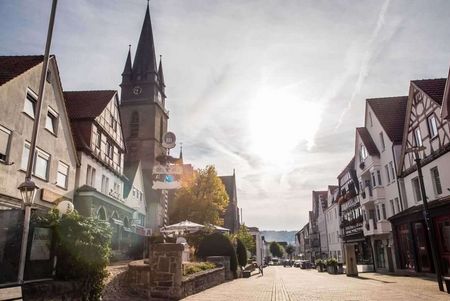 Blick in die obere Fußgängerzone Bad Driburgs mit der Kirche St. Peter und Paul im Hintergrund.