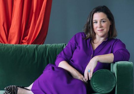 Autorin Annika Reich auf einem grünen Sofa.